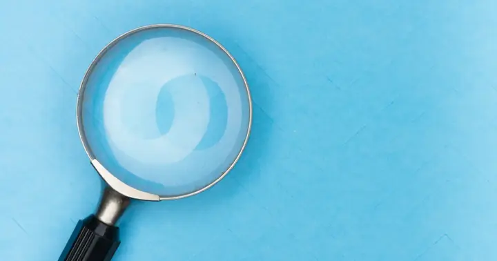 A magnifying glass over a light blue background