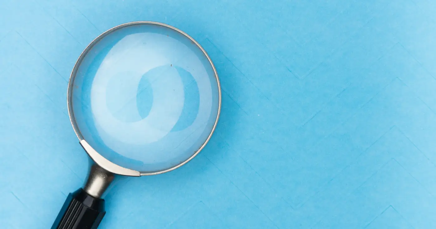 A magnifying glass over a light blue background